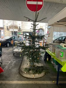 Weihnachtsbaum und Essensstände auf einem Parkplatz unter der Brücke am Österreichischen Platz in Stuttgart